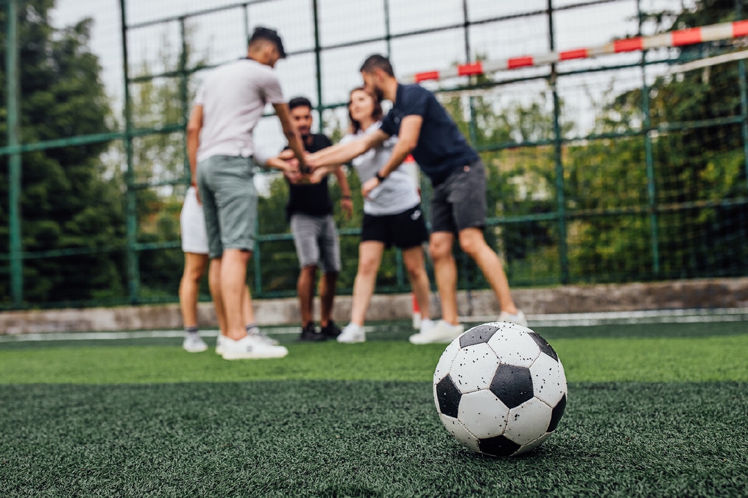 images/close-up-football-ball-green-field-players-going-playing-together.jpg