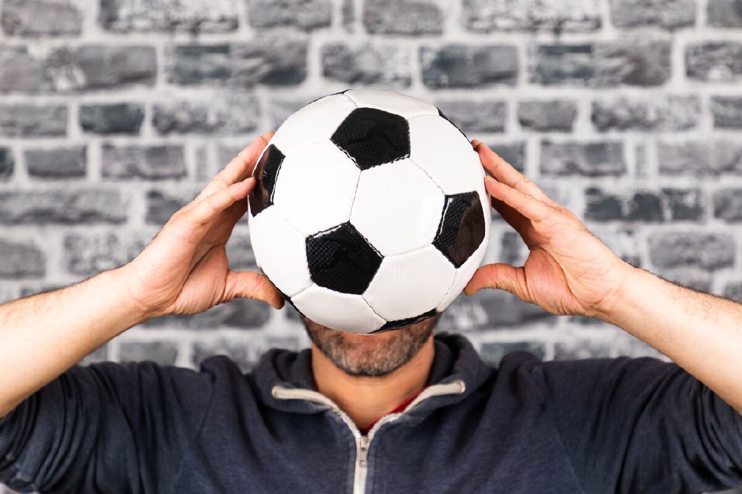 images/close-up-man-holding-soccer-ball-against-wall.jpg